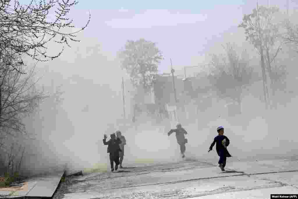 Әфган балалары Кабулда хәрби боралак төшкәндә очырган тузан эчендә йөгерә. 