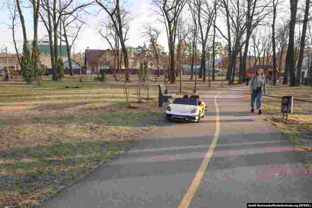 Цела жанчыны ў ірпеньскім парку Дубкі. У цяперашні час нічога не паказвае на тое, што тут месца гібелі чалавека.Зьлева фота 11 сакавіка 2022 году, справа — з сакавіка 2025 году