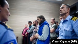 Kosovo police officers stand guard as the convicted plotters are sentenced in Pristina on May 18. 
