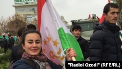 Журналистка Радио Озоди держит в руках флаг Таджикистана