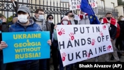 Грузинські активісти тримають плакати на акції з підтримки України перед посольством України в Тбілісі. Грузія, 23 січня 2022 року