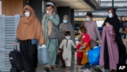 Families evacuated from Kabul, Afghanistan walk through the terminal after they arrived at Washington Dulles International Airport in September 2021. (file photo)