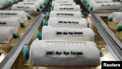 Германияда шприц формасында даярдалган таттуу токочтор. Сыртына "2021 - кош бол, корона" деп жазылган. 
