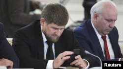 Chechen leader Ramzan Kadyrov (left) seems very attached to his cell phone and is an active Instagram user. (file photo)
