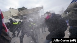 Трамптын жаалданган тарапташтары менен полиция кагылышып жаткан учур. 6-январь, 2020-жыл.