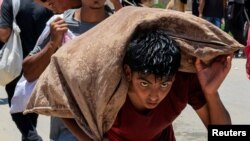 Газанын гуманитардык фондунан жардам алган палестиналык бала. Рафах, 9-июнь, 2025-жыл.