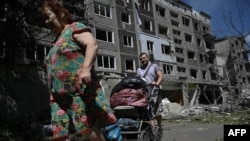 Місцеві жителі виносять свої речі з пошкодженого житлового будинку після російського удару в місті Білозерське (неподалік Добропілля) Донецької області, 12 серпня 2025 року