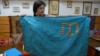 Леране Хайбуллаєва з кримськотатарським прапором