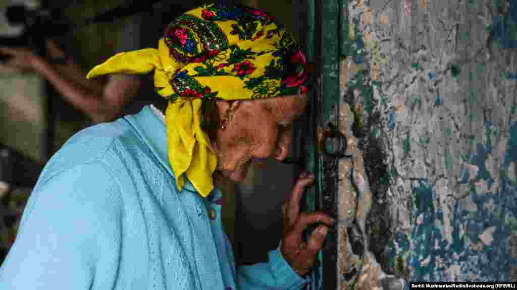 Пожилая жительница заброшенного поселка Опытное стоит рядом с аэропортом Донецка, который считается&nbsp;зоной войны в Украине. 4 июня. (Serhii Nuzhnenko, RFE/RL)