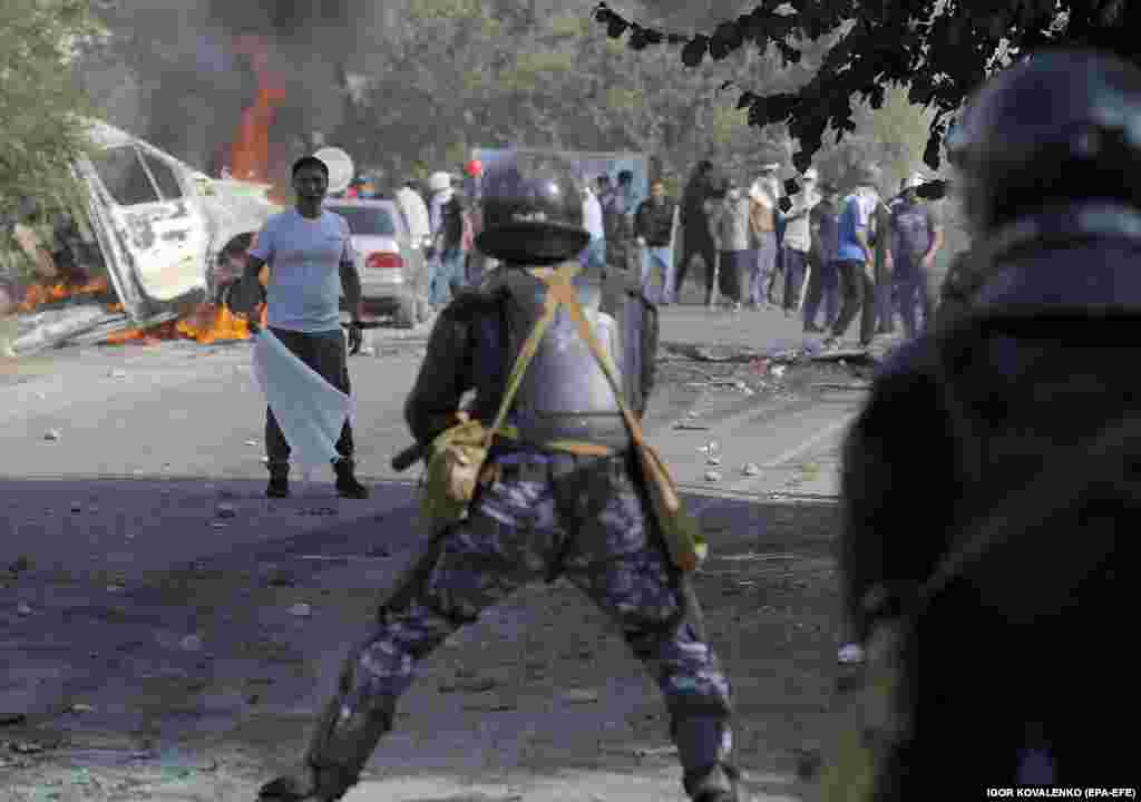 Atambaev supporters and police face off on a road near the compound.&nbsp;
