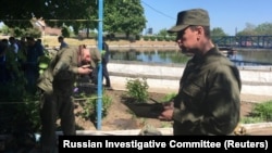 Investigators work at the site of the accident at the sewage plant in the village of Dmitriadovka outside Taganrog.