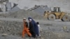 A family walks near an open cast mine in the Nangarhar region of eastern Afghanistan.