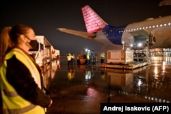 Workers unload containers holding 500,000 doses of China's Sinopharm vaccine from a special Air Serbia flight at Belgrade's airport on February 10.