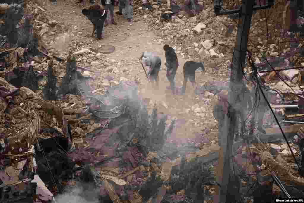 Люди розбирають завали на місці російської атаки у Петропавлівські Борщагівці