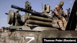 Украинский военный на захваченном российском танке с символом "Z", Украина, Харьковская область, март 2022