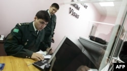 Migrasiýa gullugynyň işgäri pasport barlaýar. Arhiwden alnan surat