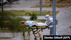 Коронавируска чалдыккан бейтапты сүйрөп бараткан медкызматкер. Москва, 30-июнь, 2021-жыл.