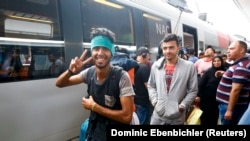 Германияга жөнөп жатканына сүйүнүп турган мигранттар. Австрия, Вена, 5-сентябрь, 