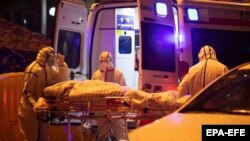 کارمندان صحی چین شخصی را که مصاب به ویروس کرونا شده به شفاخانه انتقال می‌دهند. 23 January 2020