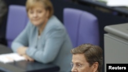 Germaniýanyň kansleri Angela Merkel (çepde) we daşary işler ministri Gido Westerwelle