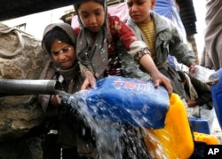 Суу толтуруп жаткан оогандык кыз. Архив