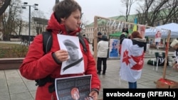 Удзельніца пікету з партрэтам Рамна Бандарэнкі, які стаў адным з сымбаляў змаганьня беларусаў за свае нацыянальныя сымбалі і супраць дыктатуры Лукашэнкі