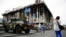 A woman takes a picture of an armoured vehicle left as a monument on Kyiv's Independence Square, known as the "Maidan."