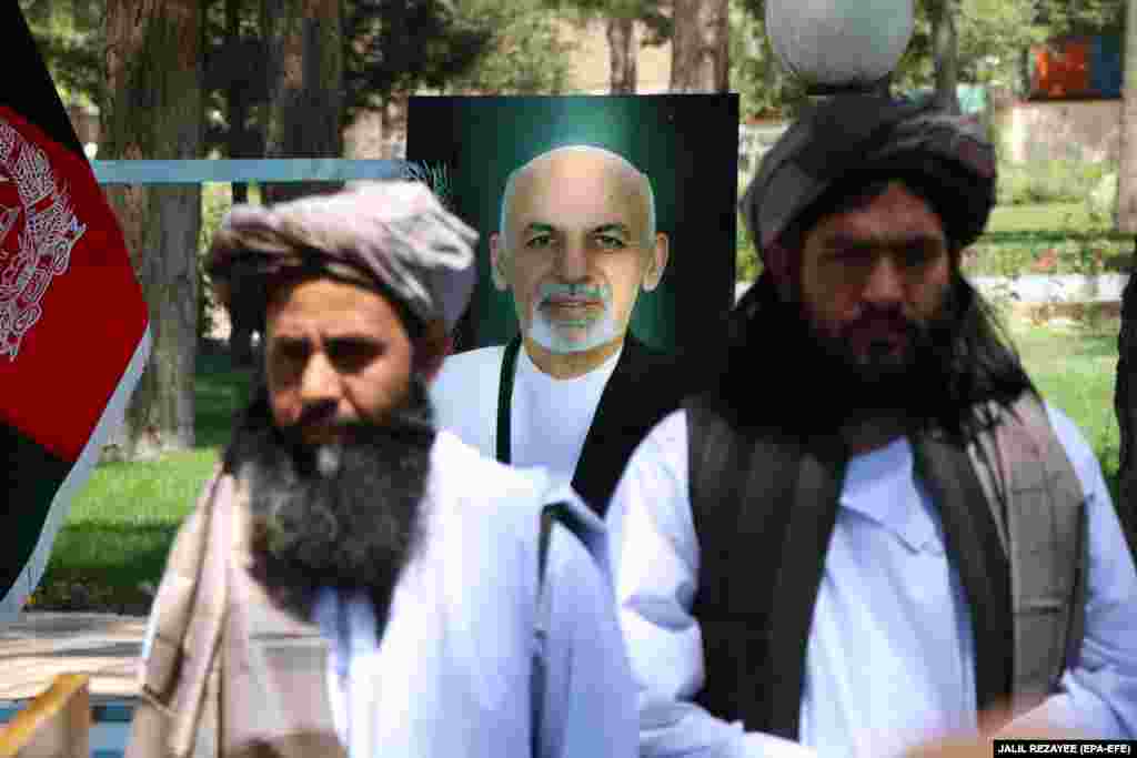 Колишні в&#39;язні-таліби стоять на тлі портрету президента Афганістану Ашрафа Гані під час процедури звільнення їх урядом. Герат, 26 травня 2020 року