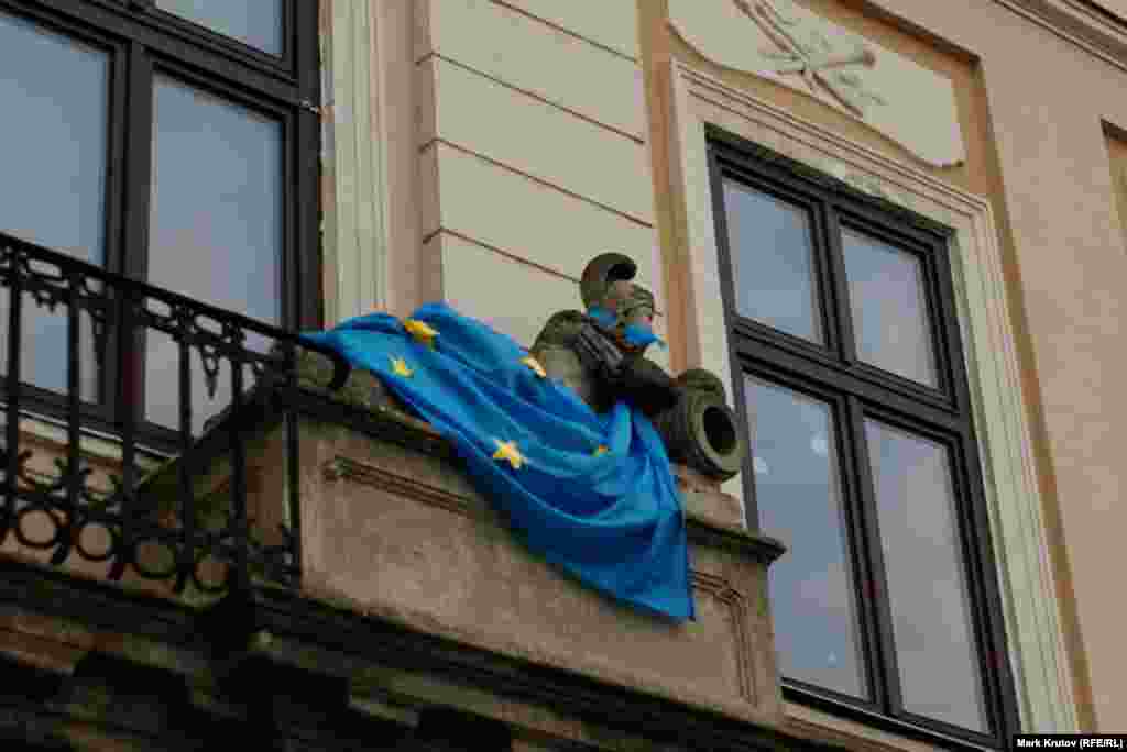 Флаги ЕС декорирует фигуры на фасаде здания в центре Львова