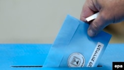 Израилдеги шайлоодо үкөккө бюллетень таштап жаткан адам. 17-март, 2015-жыл 