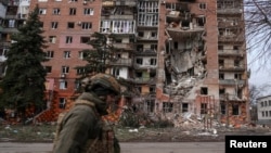 Украиналык аскер Орусиянын Донецк облусунун Покровск шаарына жасаган соккусунан жабыркаган турак жайдын жанынан өтүп бара жатат, 6-март, 2025-жыл.