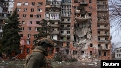 Украинский военнослужащий проходит мимо жилого дома, поврежденного в результате российских ударов по городу Покровск Донецкой области, 6 марта 2025 года