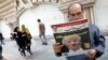 IRAN -- An Iranian man reads a copy of the daily newspaper 'Omid Javan' bearing a picture of US President Donald Trump with a headline that reads in Persian "Crazy Trump and logical JCPOA (Joint Comprehensive Plan of Action)", inTehran, October 14, 2017
