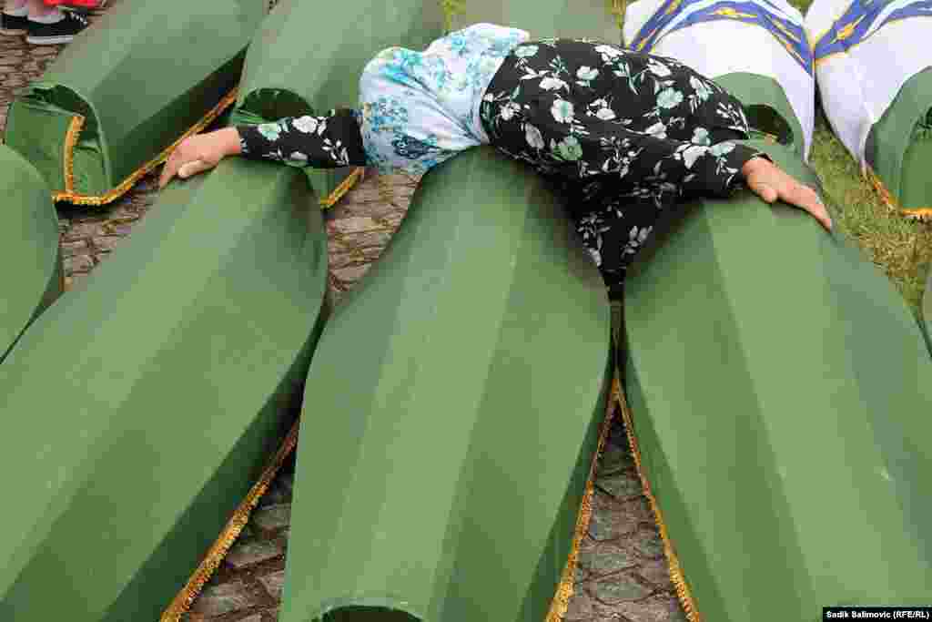A woman mourns over the coffin of a loved one.