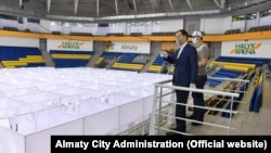 Almaty Mayor Bakytzhan Sagintayev (left) inspects the construction of a temporary COVID-19 hospital in the Halyq Arena in Almaty. (file photo)