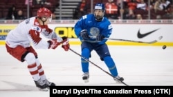 Казахстанский хоккеист Диас Гусейнов (справа) против датчанина Лассе Мортенсена в матче на МЧМ–2019, Ванкувер, 2 января 2019 года.
