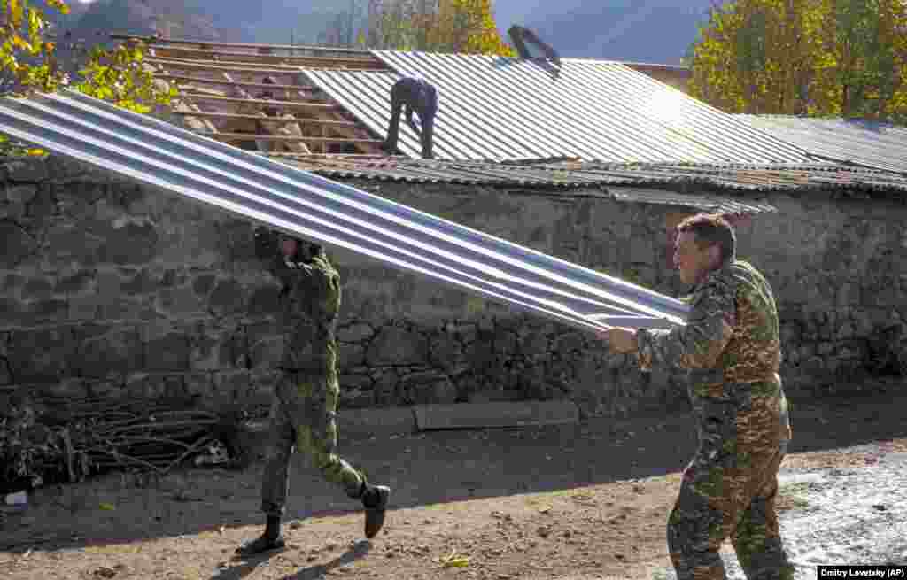 Чоловік рятує жерстяний дах свого будинку в Карвачарі/Кельбаджарі перед тим, як спалити будівлю