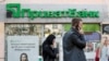 People walk past a branch of PrivatBank, the country's biggest lender, in Kyiv.