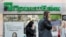 People walk past a branch of PrivatBank, the country's biggest lender, in Kyiv.