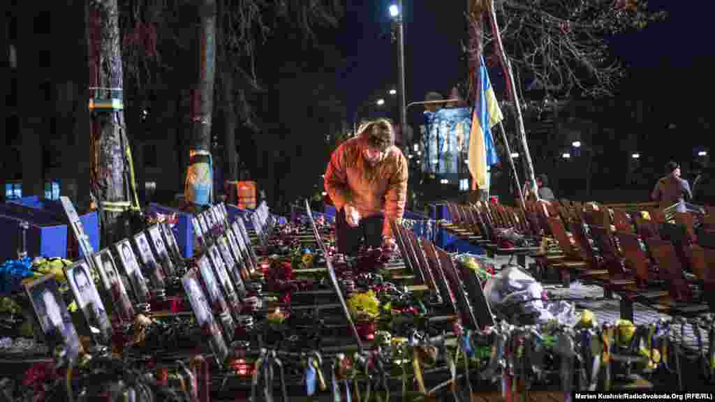 Жінка запалює свічки біля&nbsp;пам&#39;ятника Героям Небесної сотні&nbsp;