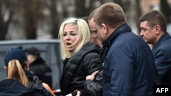 Мария Максакова в сопровождении полицейского после убийства Дениса Вороненкова в Киеве, 23 марта 2016 года