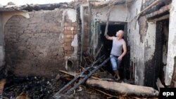 Қырғызстан төтенше жағдайлар министрлігінің өкілі «терроршылар тобына» қарсы арнайы операцияда бұзылған үйдің орнында тұр.  Бішкек, 17 шілде 2015 жыл.