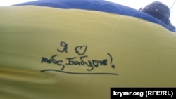 Послания, написанные на флаге Украины, который запустили в Крым