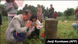 Японцы на могиле предков на кладбище на острове Кунашир (архивное фото)