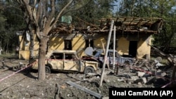 AZERBAIJAN -- Police block the area around destroyed cars and buildings, following a missile attack by Armenian forces, in the city of Barda, October 8, 2020