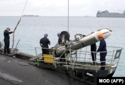 Військовослужбовці британського флоту завантажують ракету «Томагавк» на підводний човен класу T Королівського флоту на базі ВМС США в Дієго-Гарсія. Фото опубліковане Міністерством оборони Великої Британії 16 листопада 2001 року