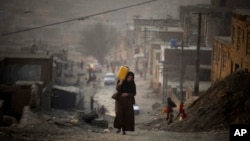 Кабул тұрғыны су толы ыдысты көтеріп барады. 2010 жыл.