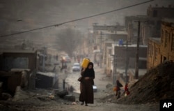 Пластик идишда сув кўтариб олган кобуллик аёл (архив).