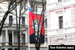 Стилізований плакат із зображенням «черепа смерті» президента РФ Володимира Путіна на фасаді Музею історії медицини перед будівлею російського посольства, Рига, Латвія, 17 березня 2024 року