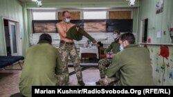 Солдати на Донбасі, а ще медики, згідно з розпорядженням уряду, перші в черзі на отримання вакцини. На фото: військові ЗСУ отримують вакцину від ковіду в Авдіїївці, біля лінії зіткнення. Зона бойових дій, Авдіїка, Донецька область